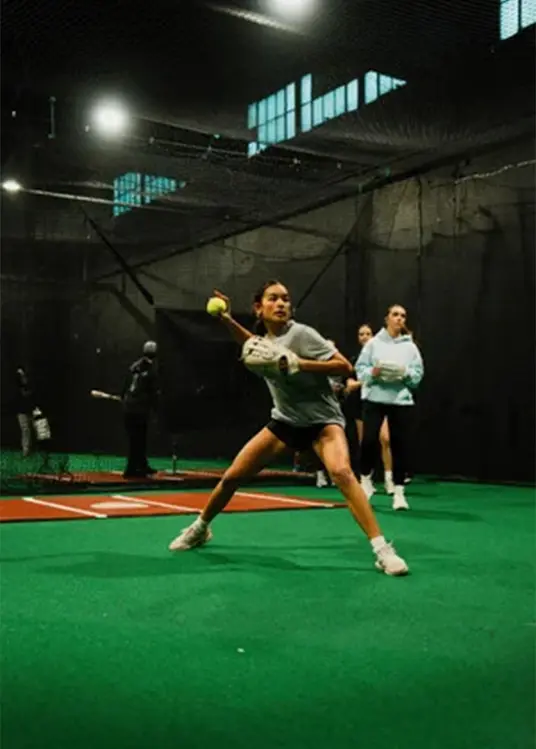 A softball player training inside CYOJ Hit Lab