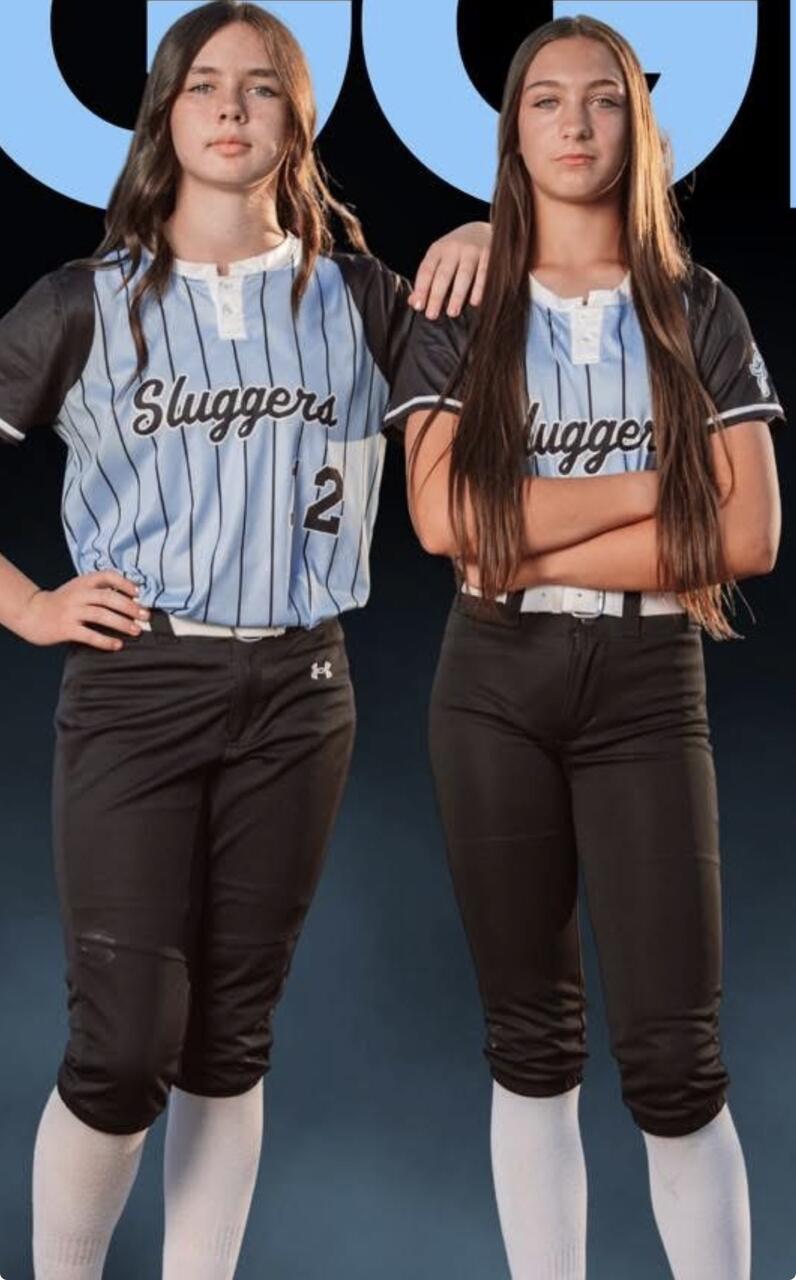 Two Salem Sluggers Fastpitch players in team uniforms