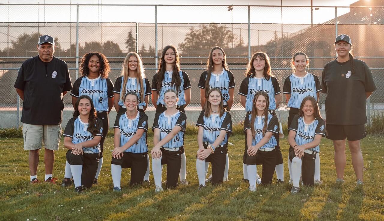 Salem Sluggers Fastpitch team standing together at sunset